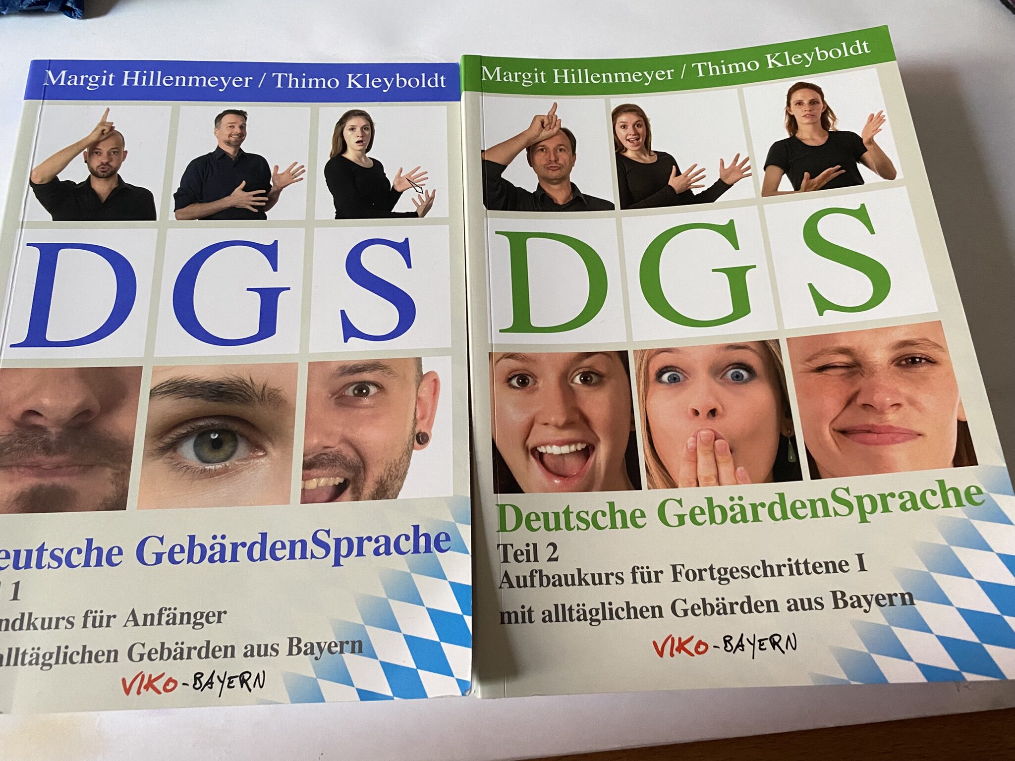 Zwei Bücher zur Deutschen Gebärdensprache für Anfänger und Fortgeschrittene liegen nebeneinander.